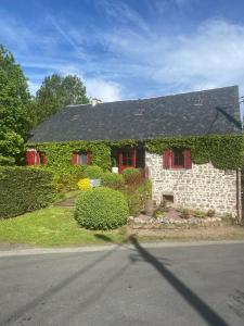 une maison avec du lierre poussant sur le côté dans l'établissement Longère 7 personnes - 4 chambres - 3 SdB Orcival, à Vernines