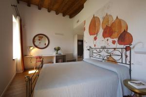 a bedroom with a bed and a wall with leaves painted on it at Corte Palù in San Martino Buon Albergo