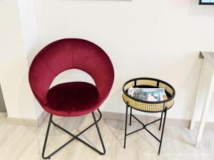 a red chair and a side table in a room at Beau Studio Neuf proche du centre et de Nausicaa in Boulogne-sur-Mer