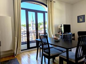 a dining room with a table and chairs and a balcony at T3 Astoria Grand Lac hyper centre in Aix-les-Bains