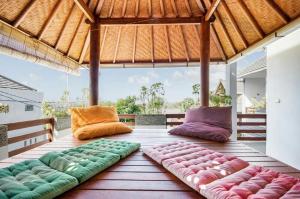 un grupo de almohadas sentadas en el suelo de madera en Villa Langit Ocean View Jimbaran, en Jimbaran