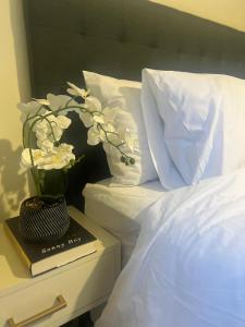 Un jarrón de flores sobre un libro en una cama. en The Nest at Greenstone Gate, en Vosburg