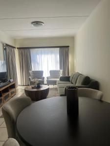 una sala de estar con un sofá y una mesa en The Nest at Greenstone Gate, en Vosburg