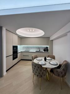 a dining room with a table and chairs and a kitchen at Bucharest Cortina North in Voluntari