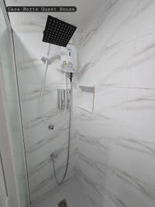 a shower in a bathroom with white marble walls at Casa-Norte Guest House in San Jose +24 photos