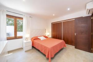 ein Schlafzimmer mit einem Bett und einem Holzschrank in der Unterkunft Casa Can Picafort in Can Picafort