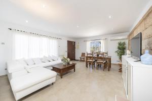 ein Wohnzimmer mit weißen Möbeln und ein Esszimmer in der Unterkunft Casa Can Picafort in Can Picafort