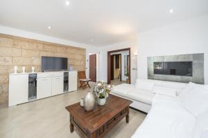 ein Wohnzimmer mit einer weißen Couch und einem Tisch in der Unterkunft Casa Can Picafort in Can Picafort + 21 Fotos