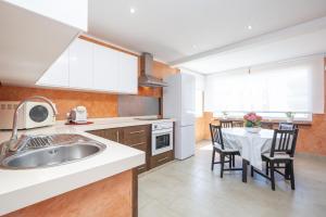 eine Küche mit Spüle und Tisch mit Stühlen in der Unterkunft Casa Can Picafort in Can Picafort