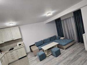 a living room with a blue couch and a table at Snow Apartament in Buşteni