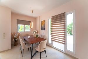 a dining room with a wooden table and chairs at SunnyVilla Rhodes in Ialysos +24 photos