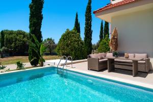 a villa with a swimming pool and a patio at SunnyVilla Rhodes in Ialysos