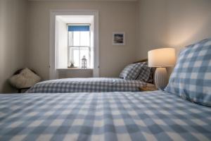 une chambre avec deux lits et une fenêtre dans l'établissement Covesea Lighthouse Cottages, à Lossiemouth