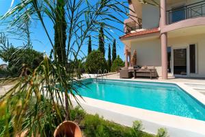 a swimming pool in front of a villa at SunnyVilla Rhodes in Ialysos