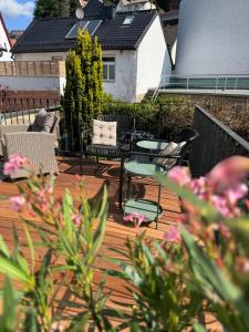 eine Terrasse mit zwei Stühlen, einem Tisch und Bänken in der Unterkunft EifelQuartier L8 in Schleiden