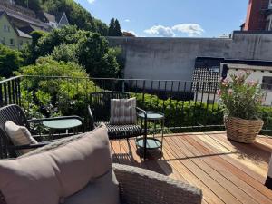 eine Terrasse mit Stühlen und einem Sofa auf einem Deck in der Unterkunft EifelQuartier L8 in Schleiden
