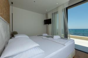 a bedroom with a white bed with a large window at Adria Resort SEAFRONT Villa C Private Pool Pet Friendly in Zaton +60 photos