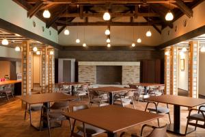 a dining room with tables and chairs and a fireplace at AMANE resort GAHAMA in Beppu