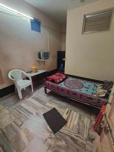 a bedroom with a bed and a table and a chair at hotel aadarsh in Sendhwa