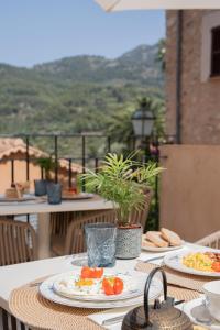 a table with plates of food on top of a balcony at Petit Biniaraix in Sóller +76 photos