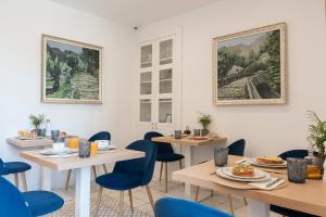 a dining room with two tables and blue chairs at Petit Biniaraix in Sóller