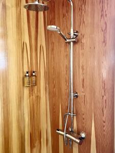 a shower in a bathroom with a wooden wall at Fjordview Ryten 1 Retreat in Sund