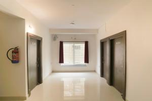 an empty room with two doors and a window at Super Hotel O Prashant Villa in Rānchī
