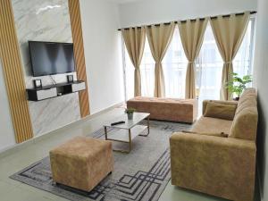 a living room with two couches and a flat screen tv at GRANDE MAISON 3 NEAR AFAMOSA WaterPark in Kampong Pulau Sebang