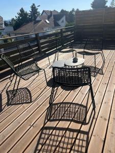 a group of chairs and a table on a deck at Duplex LOUIS - Mon Gîte Facile in Horbourg