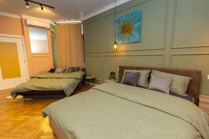 a bedroom with two beds and a blue painting on the wall at Benny & Bella Central Apartments in Oradea