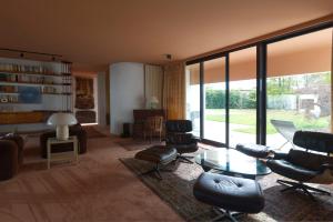 ein Wohnzimmer mit Stühlen, einem Tisch und Fenstern in der Unterkunft Villa Sugulna in Saint-Pierre-dʼIrube