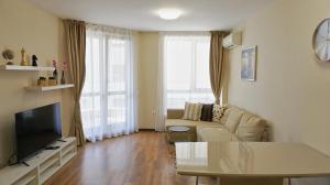 Una sala de estar con un sofá y un televisor. en Апартаменти Бяла Клиф - Byala Cliff Apartments, en Byala
