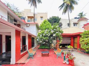 a courtyard of a house with chairs and a table at Cine Castle 4BHK Luxury Spacez Villa with Private Theatre & Garden in Bengaluru