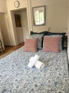 a bed with two pillows and two towels on it at Lumineux & cosy accès Paris Versailles La Défense in Suresnes