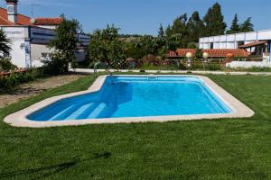a swimming pool in the middle of a yard at Alojamento O Tordo in Torrão
