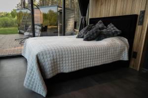 a bed with a white comforter on top of it at Torgu Kuningriigi palee in Rahuste +12 photos