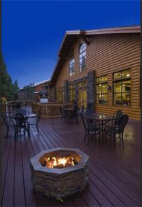 eine Terrasse mit einer Feuerstelle an einem Haus in der Unterkunft Denali Park Village in McKinley Park