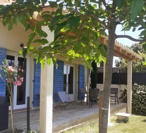 a wooden deck with chairs and a table on a house at Charmante maison atypique in Régusse