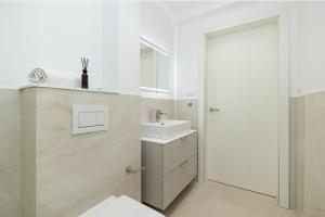 a white bathroom with a sink and a mirror at Apartament na Brzozowej in Międzywodzie +24 photos