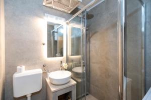 a bathroom with a sink and a toilet and a mirror at Sarajevo Midway Premium Brand New Apartment in Sarajevo +30 photos