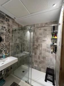 a bathroom with a shower and a sink and a glass shower stall at appartement avec vue sur mer avec belle pergola bioclimatique au terrasse in M'diq