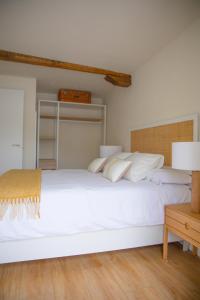 a bedroom with a large white bed with white pillows at TxOKO ETXEA in Bermeo
