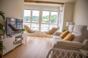 a living room with a couch and a tv at TxOKO ETXEA in Bermeo