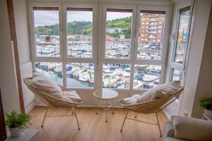 a living room with two chairs and a large window at TxOKO ETXEA in Bermeo