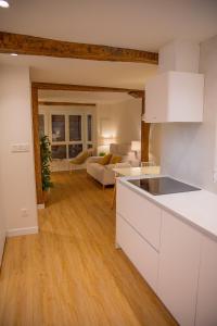 a kitchen with white cabinets and a living room at TxOKO ETXEA in Bermeo