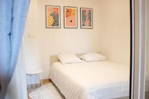 a bedroom with a bed and three pictures on the wall at Charme rare sous les voûtes in Royat