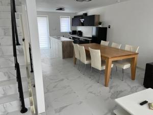 a kitchen and dining room with a wooden table and chairs at DEDIA Guest Home 