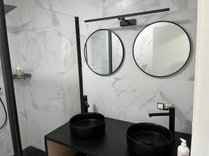 a bathroom with a black sink and two mirrors at DEDIA Guest Home 