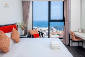 a bedroom with a bed with a view of the ocean at Rosie Hillside Seaview Phu Quoc Apartment in Phu Quoc