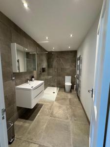 a bathroom with a sink and a shower and a toilet at Zarza House 4 bedroom Home Sleeps 8 large Garden wifi and free Parking in Hatfield